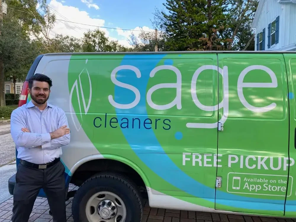 Cohen Wills standing beside a Sage Cleaners pickup and delivery van