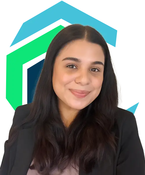 Woman with long dark hair and a black blazer smiles at the camera, standing in front of a colorful geometric background.